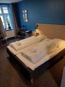 a large bed in a bedroom with a blue wall at Calm Room 10 on pedestrian street Saeby in Sæby
