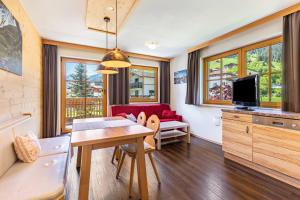 a living room with a table and a couch at Appartements Stockinger A1 in Grossarl