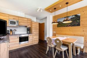 a kitchen with wooden cabinets and a table and chairs at Appartements Stockinger A1 in Grossarl