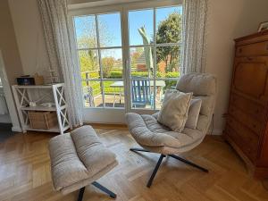 a living room with a chair and a window at Ferienhaus Niels Hus Dagebüll in Dagebüll +40 photos