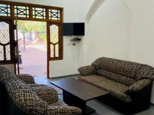 two chairs and a coffee table in a living room at Stay Home Arugambay in Arugam Bay