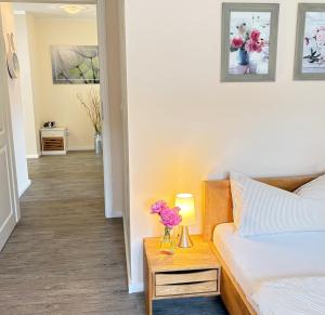 a bedroom with a bed and a table with flowers on it at Alte Schule Breese in Dannenberg