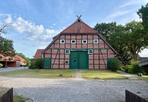 a large red brick building with a green door at Alte Schule Breese in Dannenberg