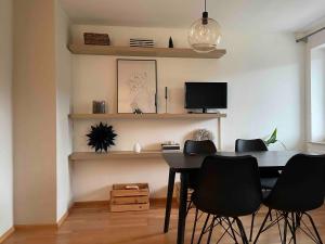 a dining room with a table and chairs and a tv at Moderne Ruheoase Allgäu in Oberreute