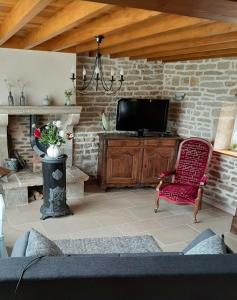 a living room with a tv and a red chair at Gite de Cerney in Marcilly-Ogny