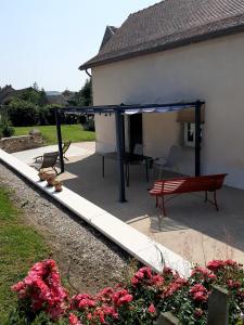 a patio with a picnic table and a bench at Gite de Cerney in Marcilly-Ogny