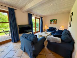 a living room with blue couches and a tv at Theodor Heuss in Westerland