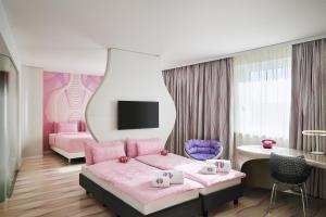 a pink bedroom with a bed and a desk at nhow Berlin in Berlin