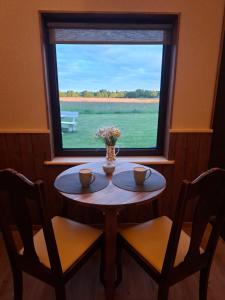 a table with two chairs and a window at Pärna Muhu Island 2 in Paenase