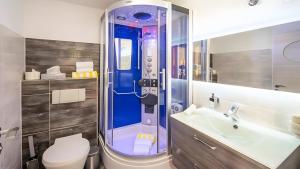 a bathroom with a shower and a toilet and a sink at Apartment Seeterrasse in Schalkenmehren +11 photos