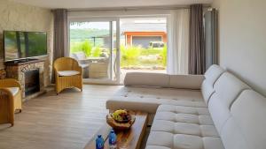 a living room with a white couch and a fireplace at Apartment Seeterrasse in Schalkenmehren
