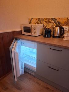 a microwave sitting on a counter next to a refrigerator at Pärna Muhu Island 2 in Paenase