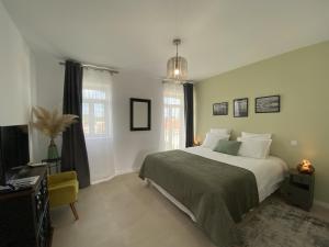 a bedroom with a bed and a chair and windows at Casa Fonte Nova in Covões