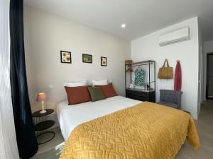 a bedroom with a large bed with a yellow blanket at Casa Fonte Nova in Covões