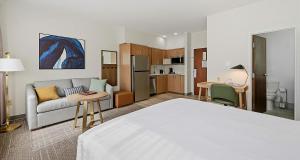 a room with a bed and a couch and a kitchen at Best Western PLUS Hannaford Inn & Suites in Cincinnati