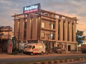 a building with a van parked in front of it at Hotel Royal Stay in Madurai