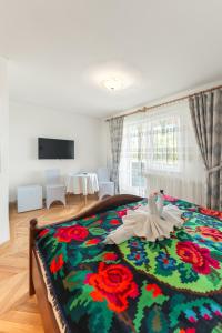 a bedroom with a bed with a colorful blanket at Pensiunea la Tăuț in Călineşti