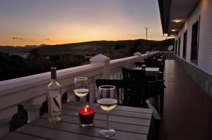 a table with wine glasses and a bottle of wine at Nueva Villa Ignacia in Arriate