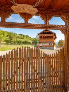 a wooden fence with a building in the background at Pensiunea la Tăuț in Călineşti