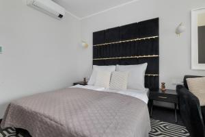 a bedroom with a bed with a black headboard at Solny Resort Apartament A245 in Kołobrzeg +8 photos