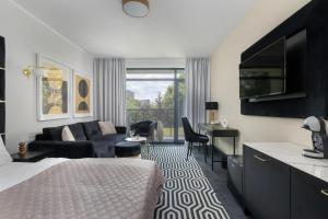 a bedroom with a bed and a living room at Solny Resort Apartament A245 in Kołobrzeg