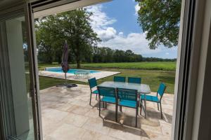 a patio with a table and chairs and a pool at Petite villa cassora in Herm