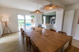 a dining room with a large wooden table and chairs at Petite villa cassora in Herm