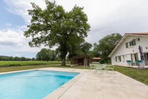 a pool with a table and chairs next to a house at Petite villa cassora in Herm