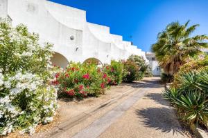 a building with flowering plants and palm trees at Le Murmure des palmiers in La Grande Motte