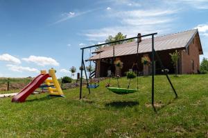 a yard with swings and a house at VIKENDICA GARAŠKI KUTAK in Arandelovac