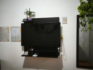 a flat screen tv hanging on a wall at Cantinho da Jessi in São Vicente +1 photo