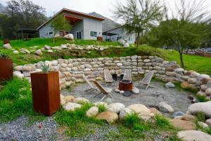 a backyard with chairs and a rock wall at Muniz Village in Three Rivers