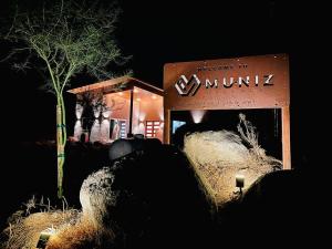 a sign in front of a building at night at Muniz Village in Three Rivers