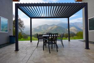 a table and chairs on a patio with a view of mountains at Muniz Village in Three Rivers