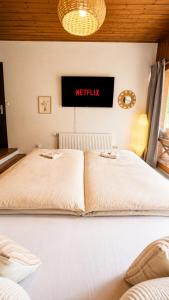 two beds in a room with a sign on the wall at Mountain View Room mit sonnigem Wintergarten in Dietmannsdorf bei Trieben