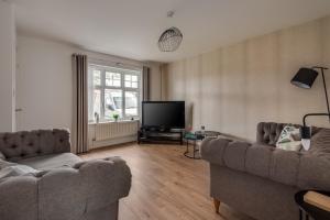 a living room with two couches and a flat screen tv at Recently Refurbished House Sleeps 5 near Stadiums in Liverpool