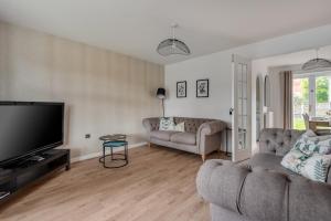 a living room with a couch and a flat screen tv at Recently Refurbished House Sleeps 5 near Stadiums in Liverpool
