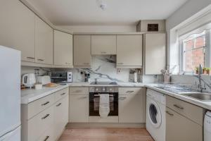 a white kitchen with white cabinets and a dishwasher at Recently Refurbished House Sleeps 5 near Stadiums in Liverpool