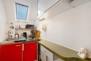 a small kitchen with red cabinets and a sink at Apartment Abendrot in Freiamt +8 photos