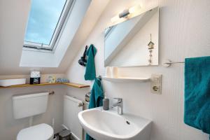 a bathroom with a sink and a toilet and a mirror at Apartment Abendrot in Freiamt