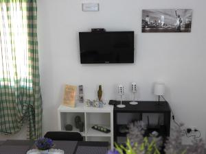 a living room with a flat screen tv on the wall at Doribella Holiday House in Pollina