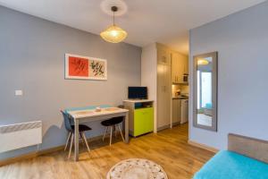 a small apartment with a table and chairs and a kitchen at Le Murmure des palmiers in La Grande Motte