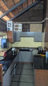 a kitchen with black counter tops in a room at Kabani Villa in Mananthavady +13 photos