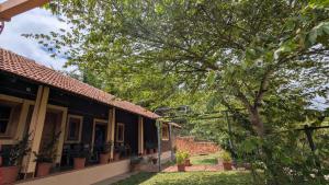 a house with potted plants and a tree at Kabani Villa in Mananthavady