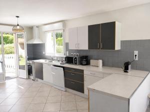 a kitchen with white cabinets and a counter top at Le balcon de Compostelle in Espaly-Saint-Marcel +18 photos