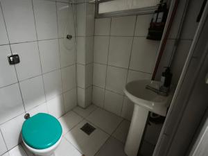 a bathroom with a blue toilet and a sink at Cantinho da Jessi in São Vicente
