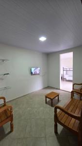 a room with two benches and a tv on a wall at Pousada Serra do Sol in Mariana