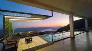 a house with a balcony with a view of a lake at Valley View Villa Wai in Wai