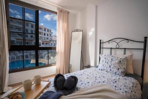 a bedroom with a bed with a view of a building at CASA VARGAS-TENERIFE in Los Cristianos +40 photos