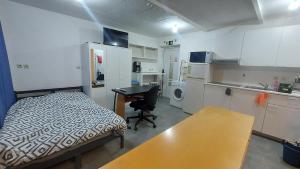 a kitchen with a bed and a desk in a room at Cozy studio apartment with 2 beds and kitchen in Audun-le-Tiche